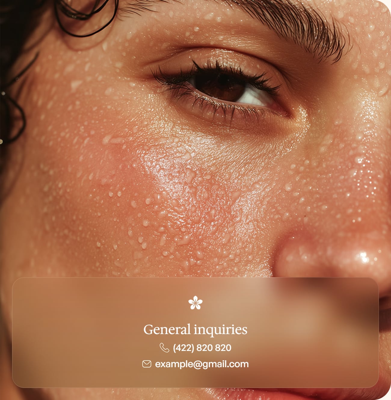Close-up of dewy, healthy skin around the eye with a general inquiries contact card